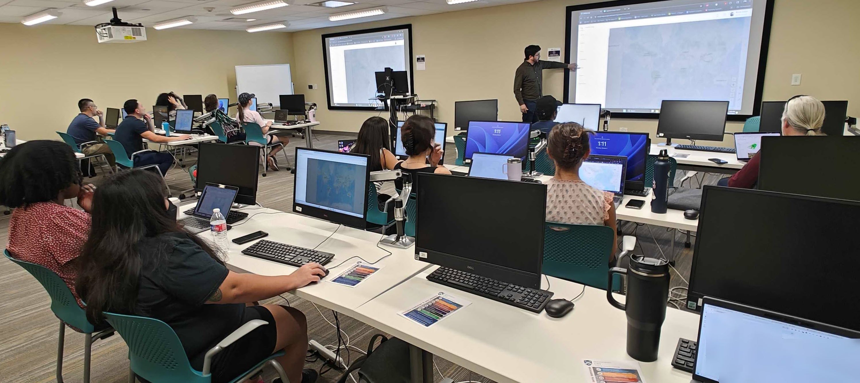 CRC representative presenting in a classroom in from of a room full of students. 